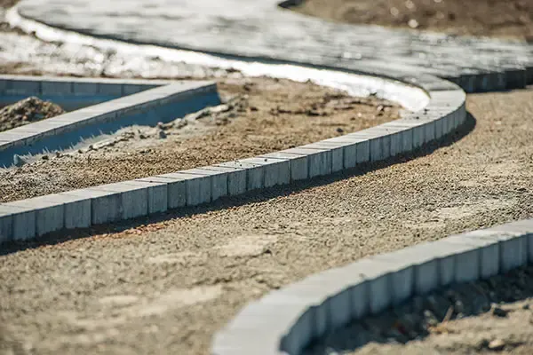 New block edging set out along a curved path on a sand base